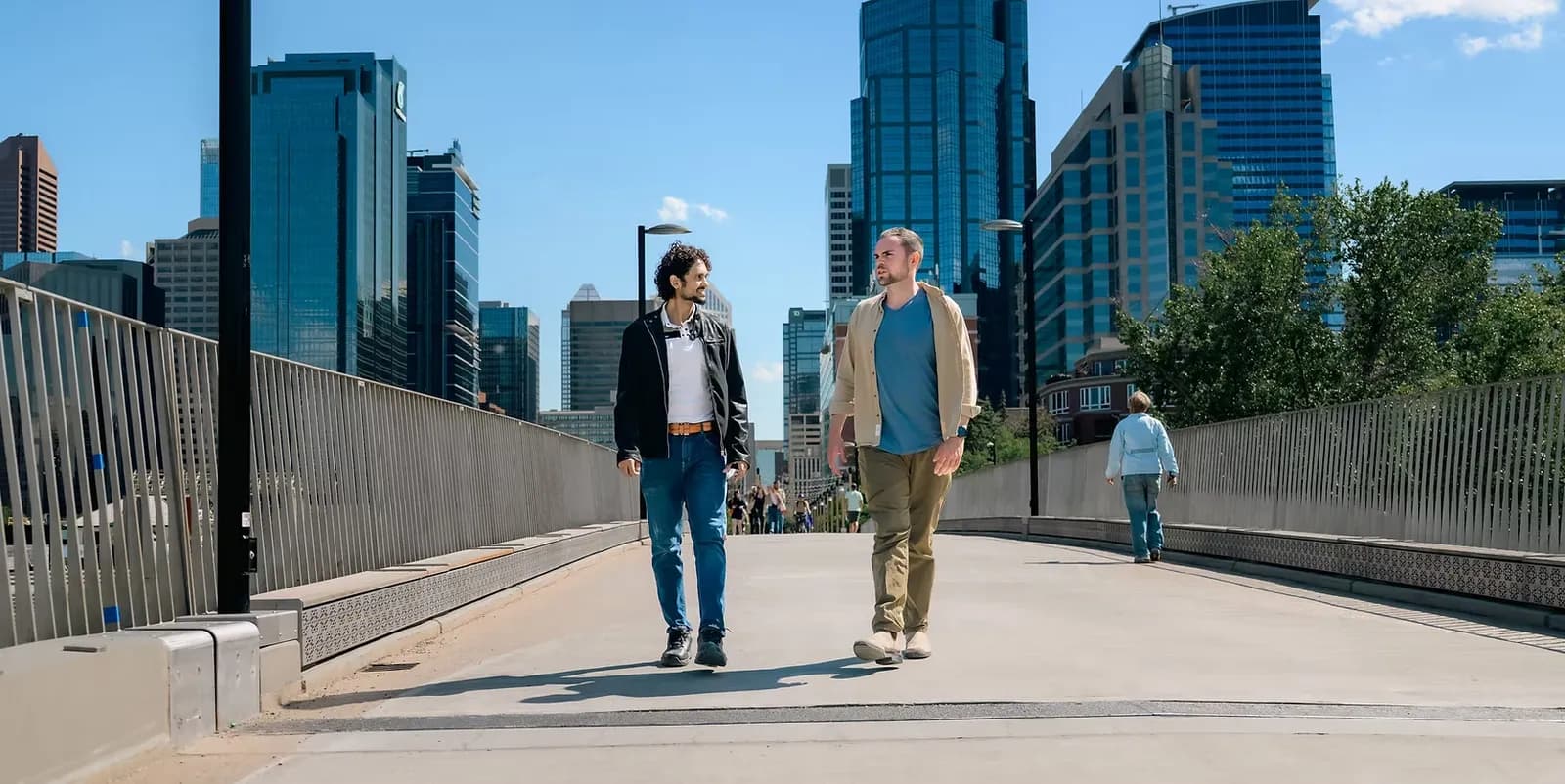 Two people in conversation while walking through downtown Calgary